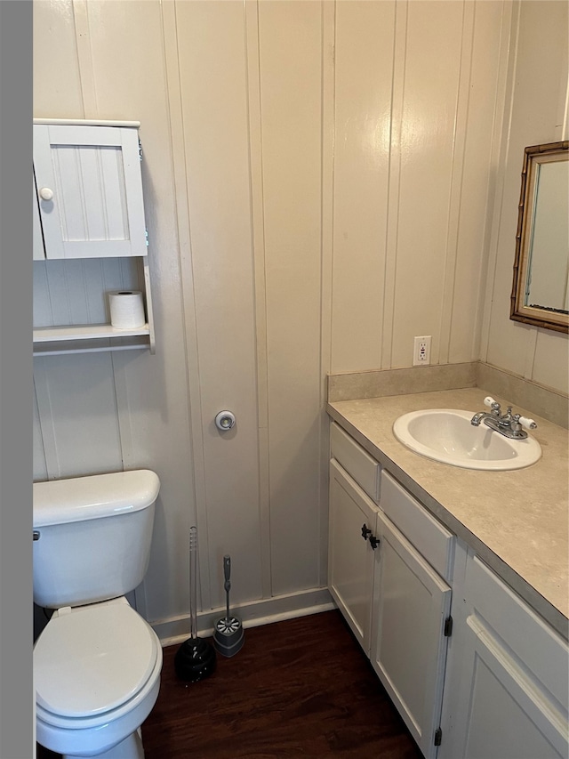 bathroom with toilet, vanity, and hardwood / wood-style flooring