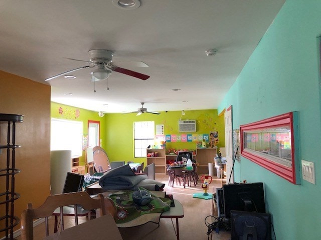 living room featuring a wall mounted air conditioner and ceiling fan