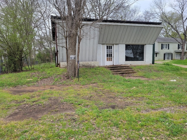 back of property featuring a lawn