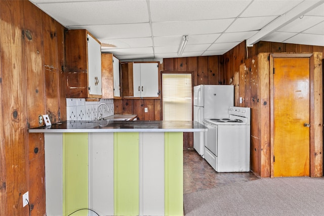 kitchen with wooden walls, stainless steel counters, a drop ceiling, dark colored carpet, and white range with electric stovetop