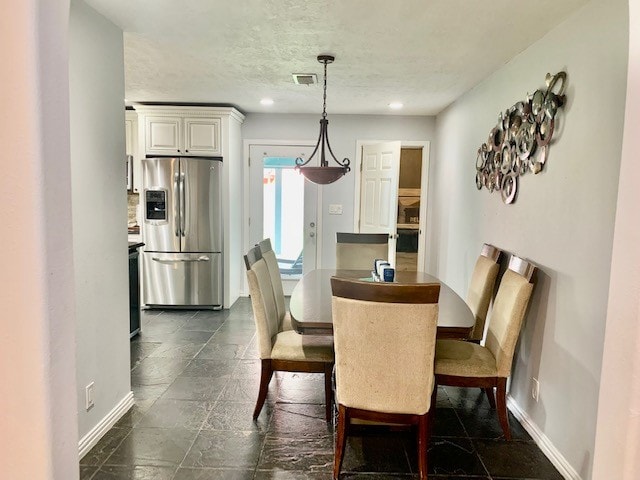 dining space featuring dark tile flooring