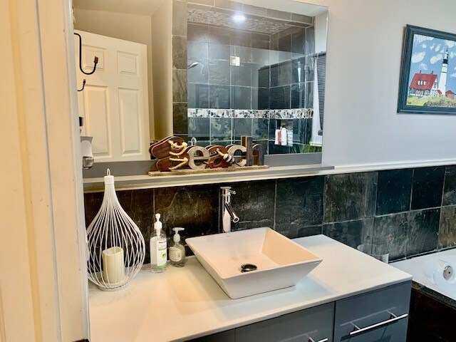 bathroom featuring backsplash and large vanity