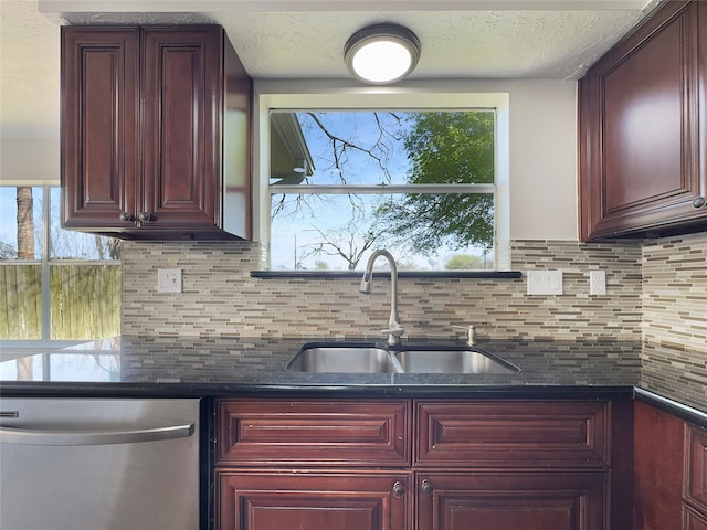 kitchen featuring backsplash, dark stone countertops, dishwasher, and sink