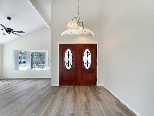 foyer featuring light hardwood / wood-style flooring, ceiling fan, and high vaulted ceiling