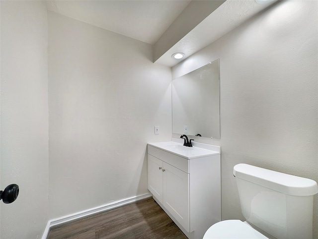 bathroom with oversized vanity, toilet, and hardwood / wood-style flooring