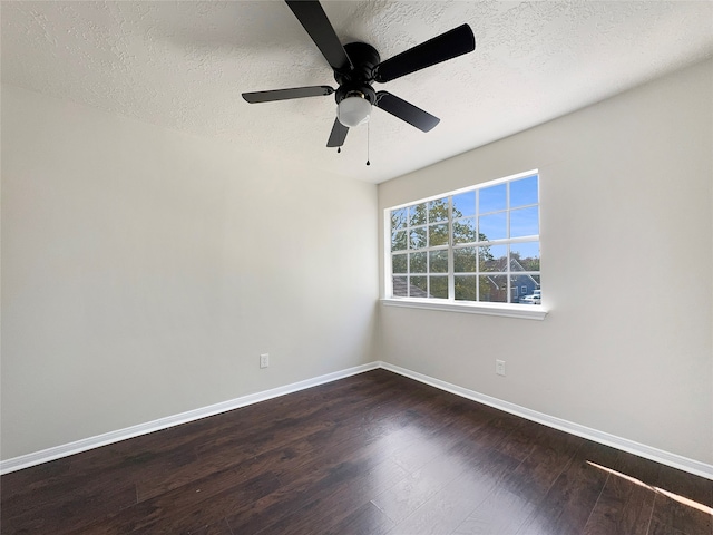 empty room with ceiling fan, a textured ceiling, and dark hardwood / wood-style flooring