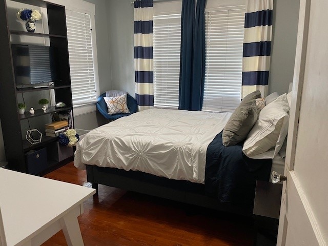 bedroom with dark wood-type flooring