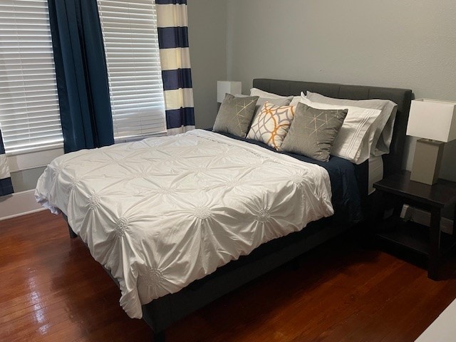 bedroom with dark hardwood / wood-style flooring