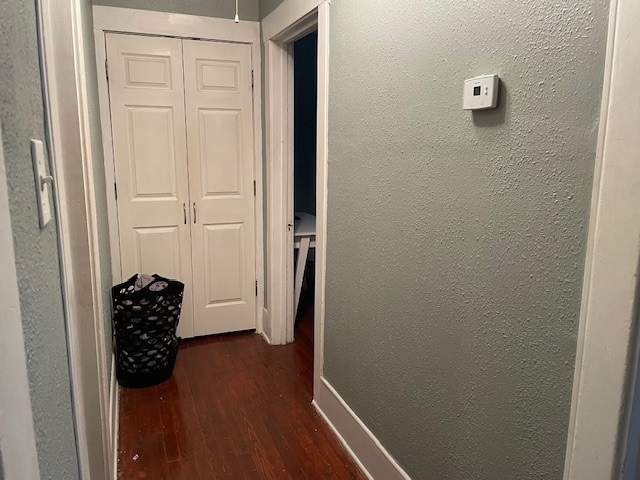 hallway with dark hardwood / wood-style flooring