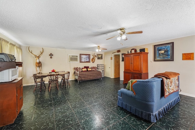 living room featuring an AC wall unit, ceiling fan, and a textured ceiling