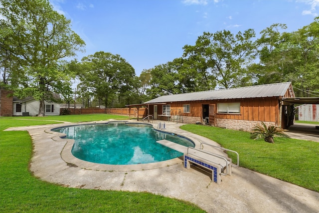 view of swimming pool featuring a yard, a diving board, and a patio area