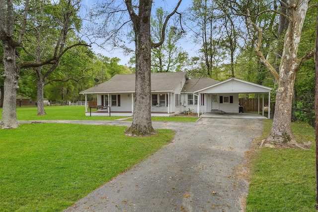 ranch-style house with covered porch, a front lawn, and a carport