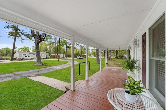 deck featuring covered porch and a lawn