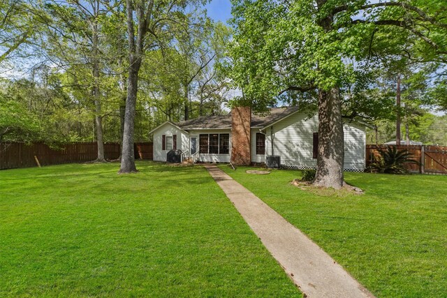 view of front of house with cooling unit and a front yard