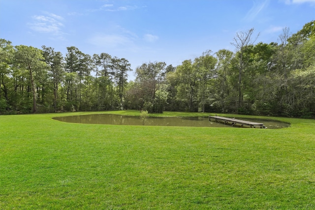 view of home's community featuring a lawn and a water view