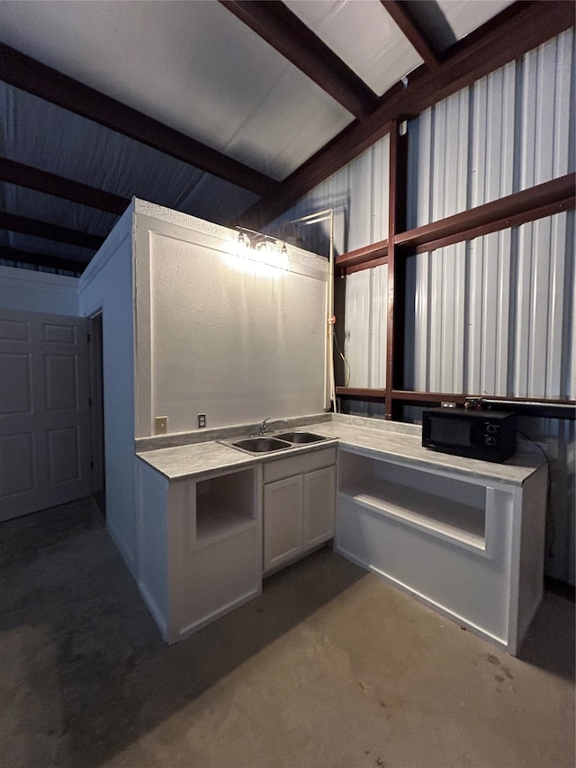 kitchen featuring beamed ceiling and sink