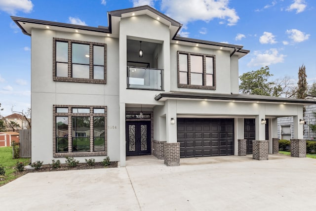 view of front of property with concrete driveway, brick siding, an attached garage, and stucco siding