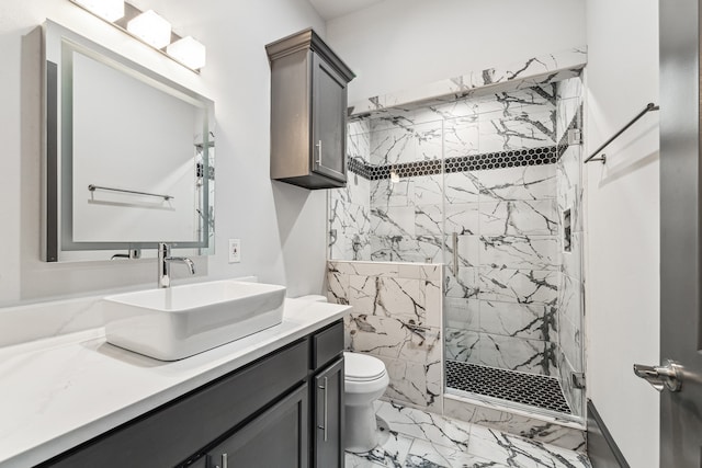 bathroom with marble finish floor, toilet, a shower stall, and vanity