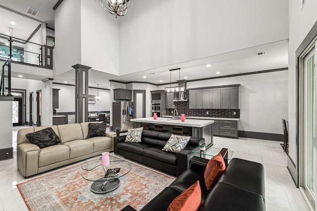 living room with ornamental molding, visible vents, decorative columns, and baseboards