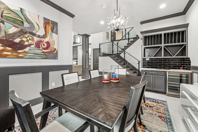 dining area with indoor bar, decorative columns, an inviting chandelier, beverage cooler, and stairs