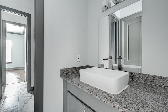 bathroom with marble finish floor and vanity