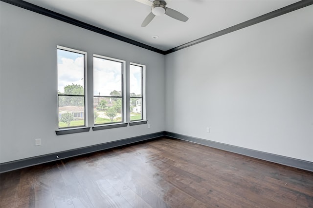 empty room with ornamental molding, dark wood-type flooring, baseboards, and a ceiling fan