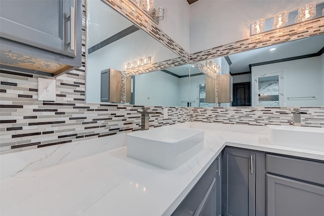 full bathroom featuring double vanity, backsplash, and a sink