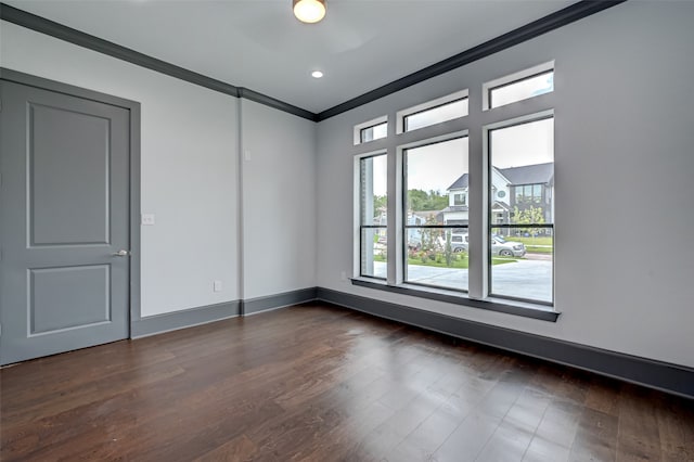 empty room featuring dark wood-style floors, recessed lighting, crown molding, and baseboards