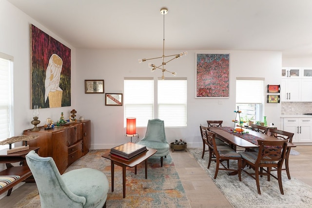 dining room with a chandelier, plenty of natural light, and light wood-type flooring