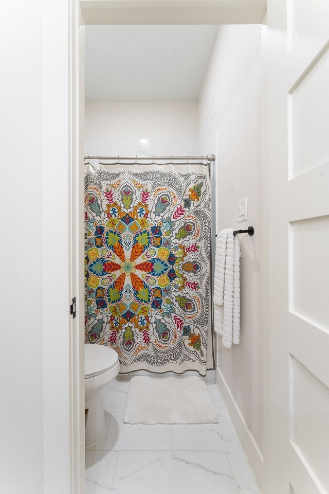 bathroom featuring tile floors and toilet