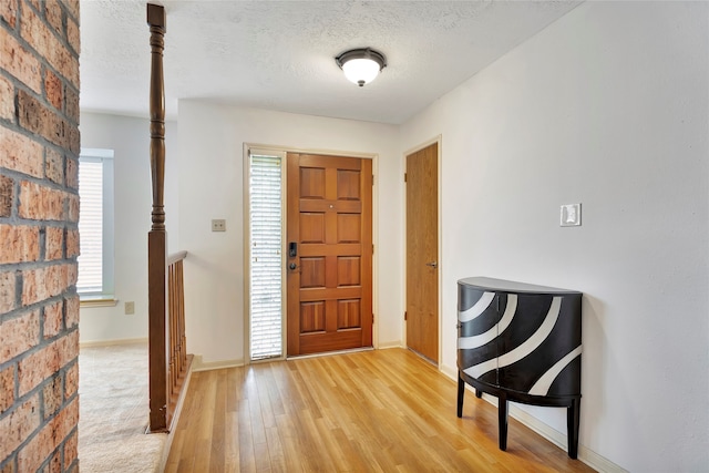 entrance foyer with light colored carpet and a textured ceiling