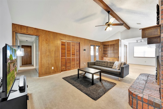 living room with lofted ceiling with beams, ceiling fan, light colored carpet, and wooden walls