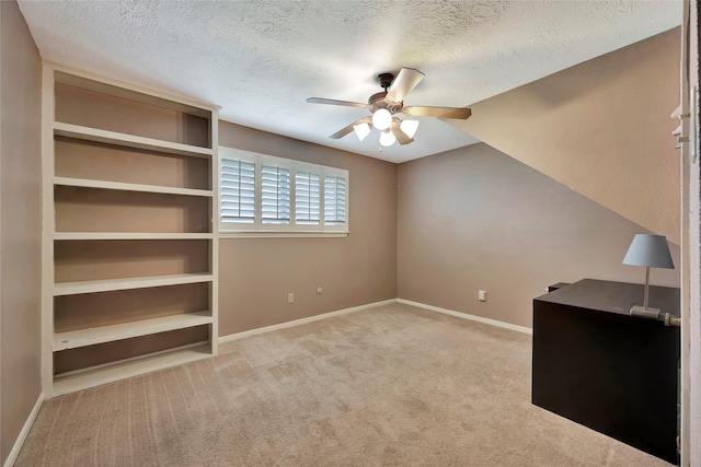 unfurnished bedroom with light colored carpet, a textured ceiling, and ceiling fan