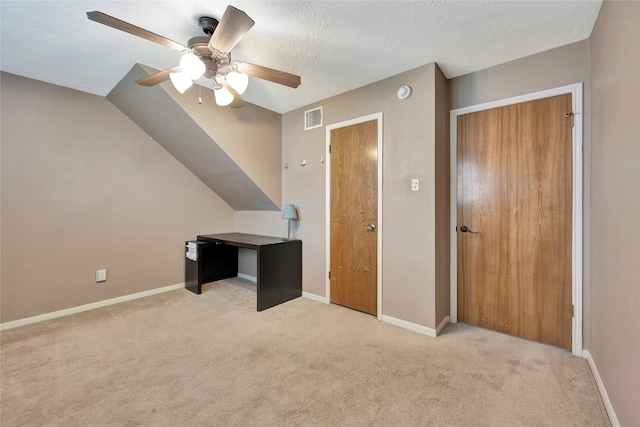 unfurnished bedroom featuring a textured ceiling, light colored carpet, a closet, and ceiling fan