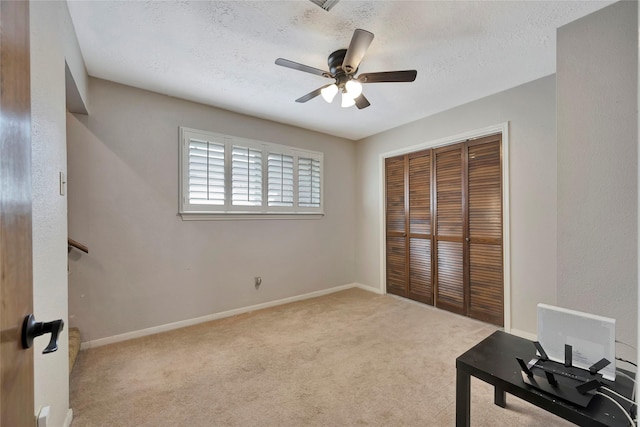 interior space with a textured ceiling, a closet, and ceiling fan