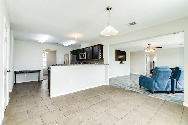 kitchen featuring hanging light fixtures, ceiling fan, appliances with stainless steel finishes, light tile patterned flooring, and kitchen peninsula