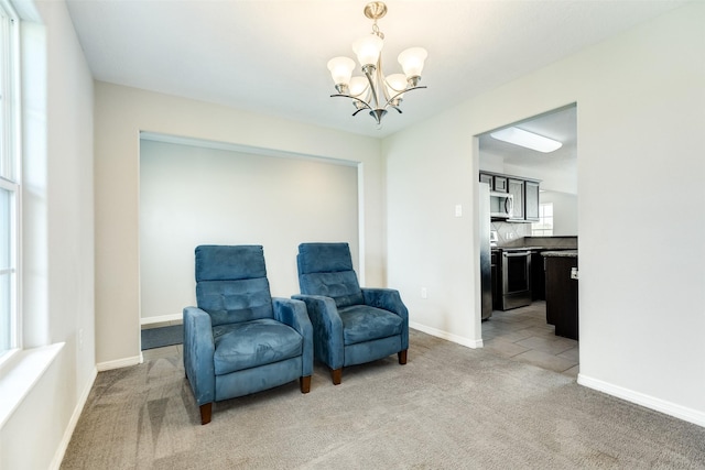 living area featuring carpet flooring and a notable chandelier