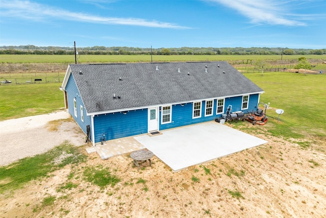 exterior space featuring a rural view, a front lawn, and a patio area