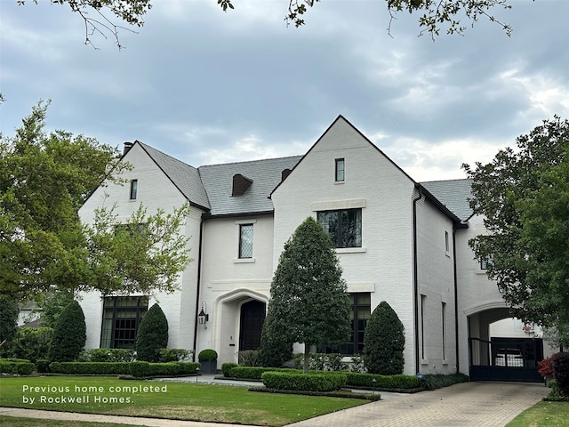 french country home featuring a front lawn