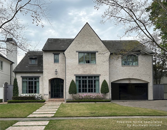 french country home with a front yard and a garage