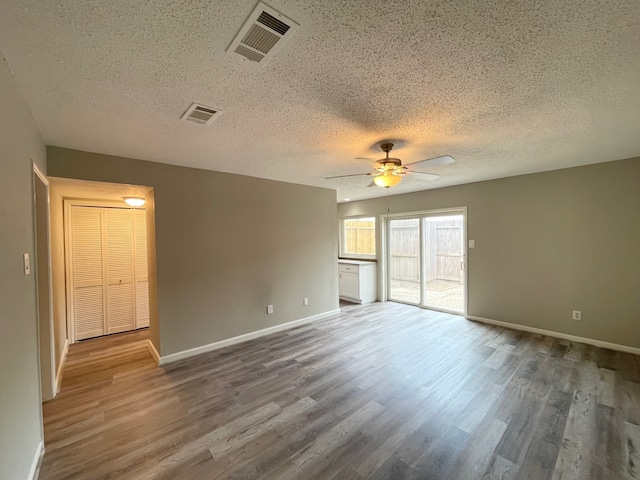 spare room with a textured ceiling, ceiling fan, and hardwood / wood-style flooring