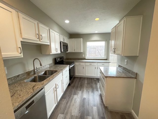 kitchen featuring sink, white cabinets, stainless steel appliances, dark wood-type flooring, and stone counters