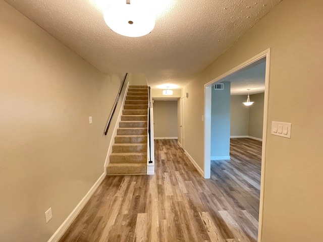 interior space with a textured ceiling and light wood-type flooring