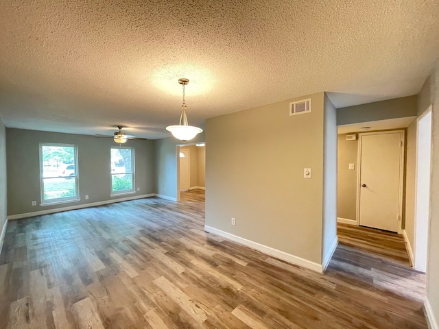 unfurnished room featuring dark hardwood / wood-style flooring, a textured ceiling, and ceiling fan