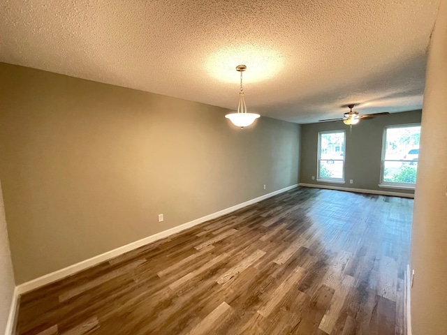 unfurnished room with dark hardwood / wood-style flooring, ceiling fan, and a textured ceiling