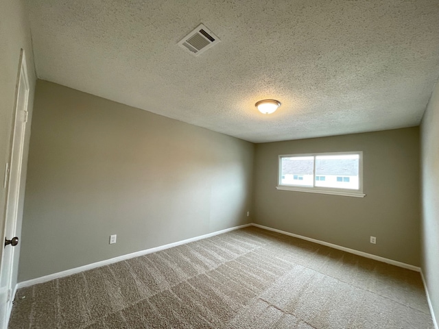 carpeted spare room featuring a textured ceiling