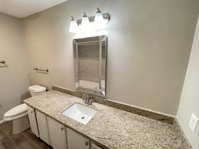 bathroom featuring vanity, hardwood / wood-style floors, and toilet