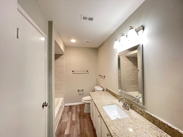 bathroom featuring toilet, vanity, and hardwood / wood-style floors