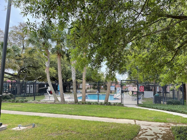 view of property's community featuring a lawn and a pool