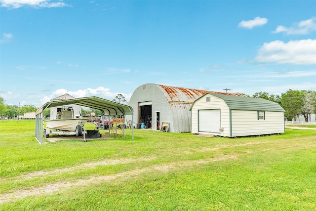 back of property featuring a carport, an outdoor structure, a garage, and a yard